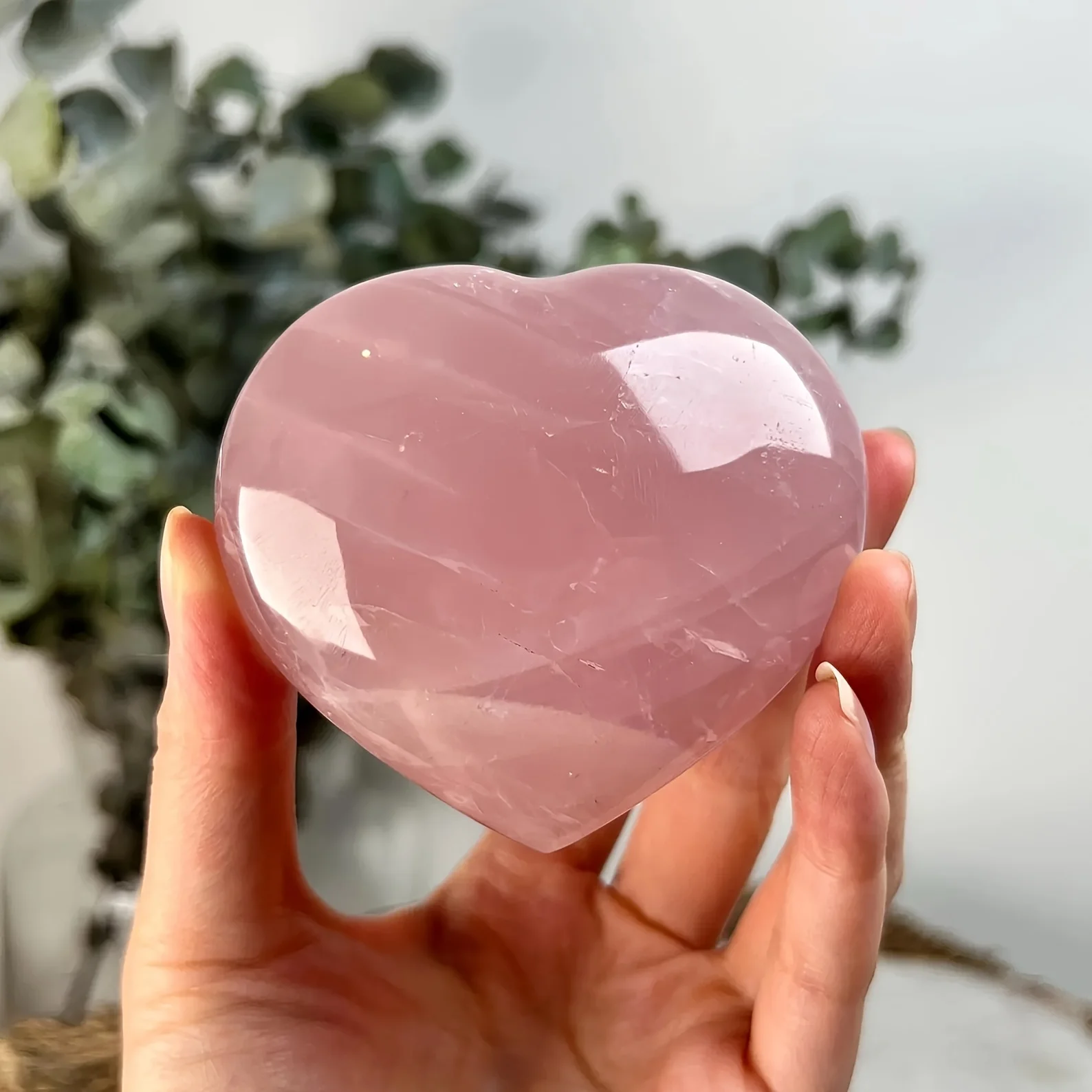 Ein herzförmiger Rosenquarzstein - rosafarbener Kristall im böhmischen Stil, herzförmiger Schnitt, Naturstein